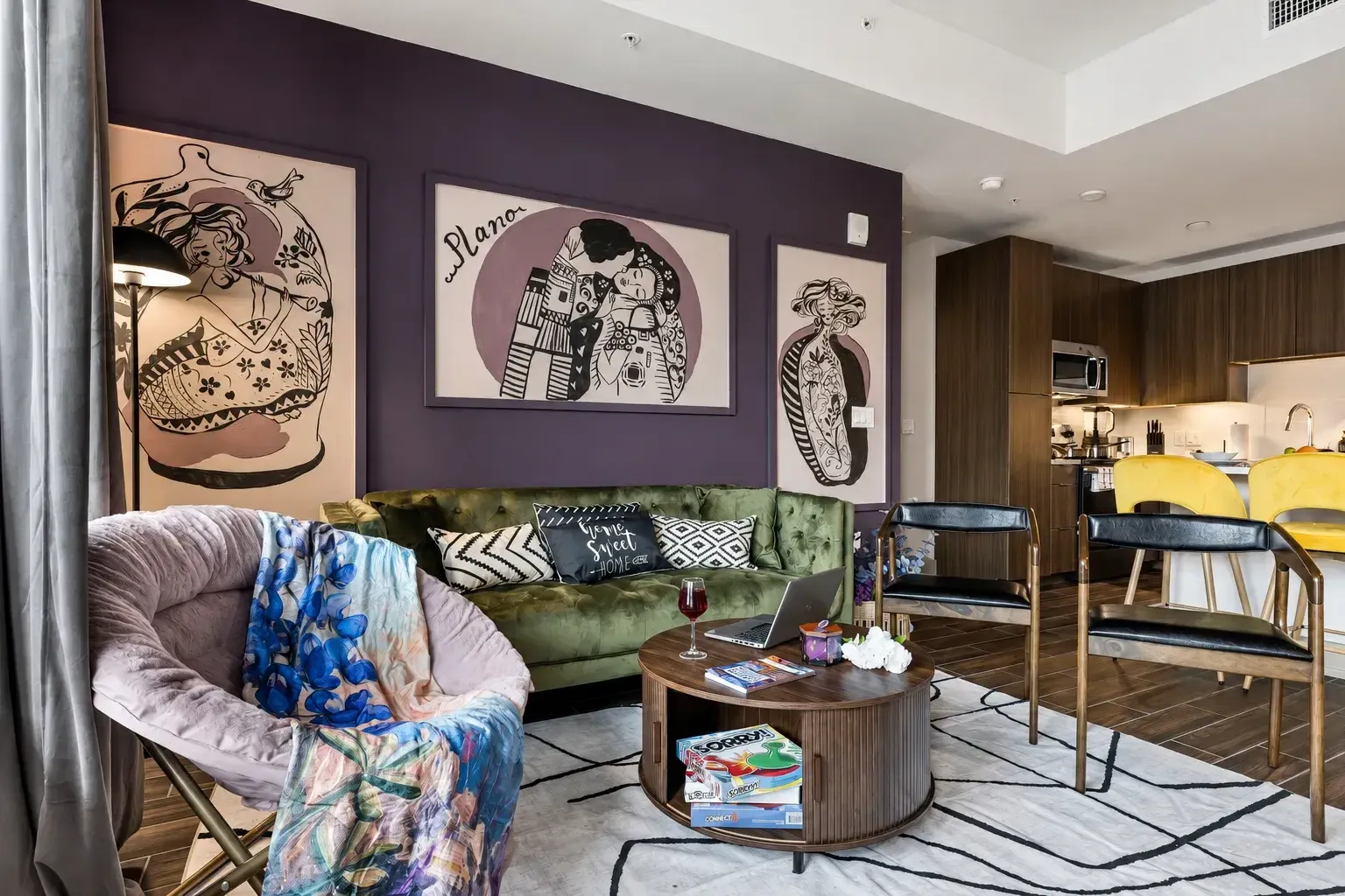 Open living room with green sofa and dining area