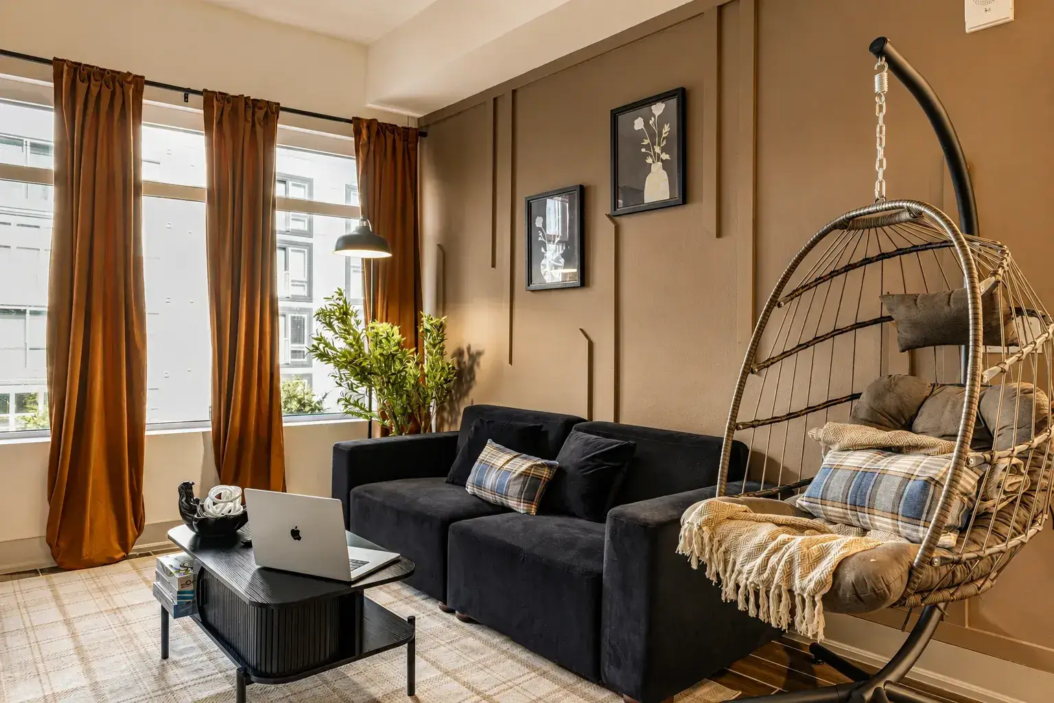 Living room with sofa, hanging chair and large windows